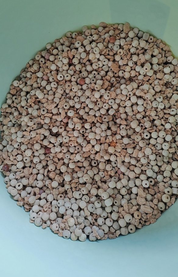 Close-up of the Zhuyun pillow's natural fill: round bamboo and wood beads mixed with cork oak bark granules